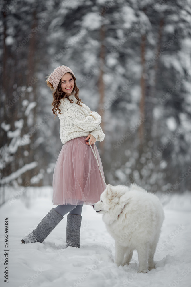 Beautiful woman with dog samoyed in winter forest Beautiful woman with dog samoyed in winter forest