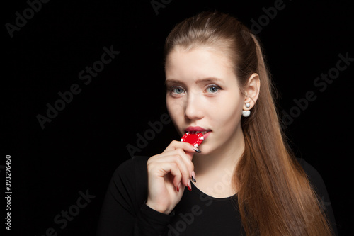 Beautiful blond woman showing gambling chips on black background