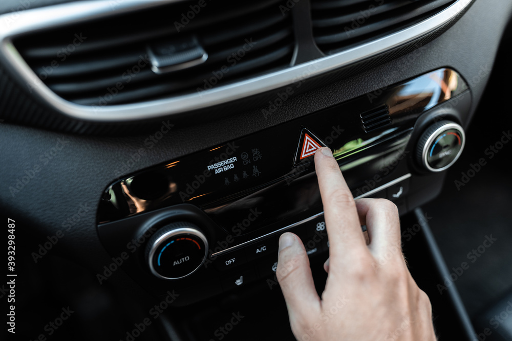 Interior view of a modern new car. Car driver pushing the attention alarm button. Interior view of a modern new car. Car driver pushing the attention alarm button.