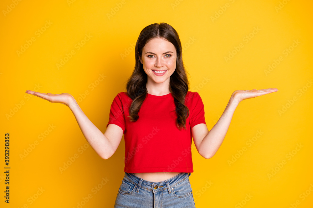 Photo of pretty lady hold open palms arms select products wear casual red cropped top jeans isolated yellow color background Photo of pretty lady hold open palms arms select products wear casual red cropped top jeans isolated yellow color background