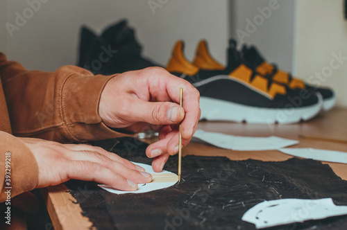 Shoemaker at work making pattern of future shoes
