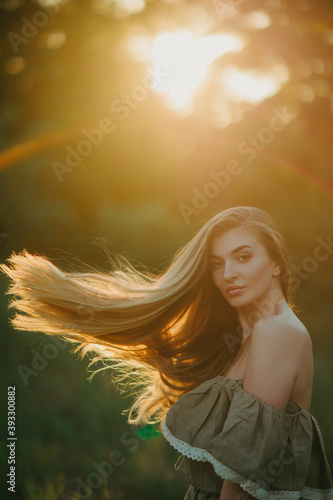 Portrait of young woman with long hair at sunset.