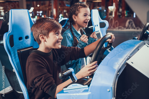 Children sit at slot machines and have fun. 