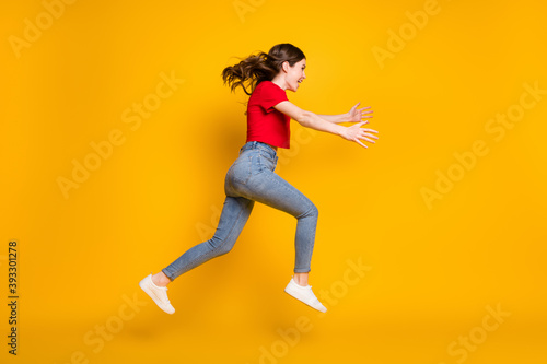 Full length profile side photo of cheerful excited girl jump run open isolated over bright shine color background