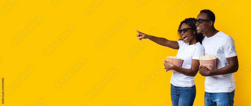 Happy black couple in 3D glasses eating popcorn