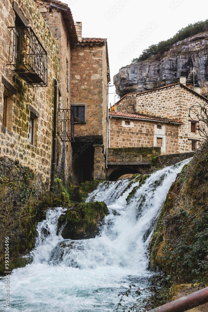 Fototapeta premium Waterfall in the streets of village of Orbaneja del Castillo in Burgos, Spain