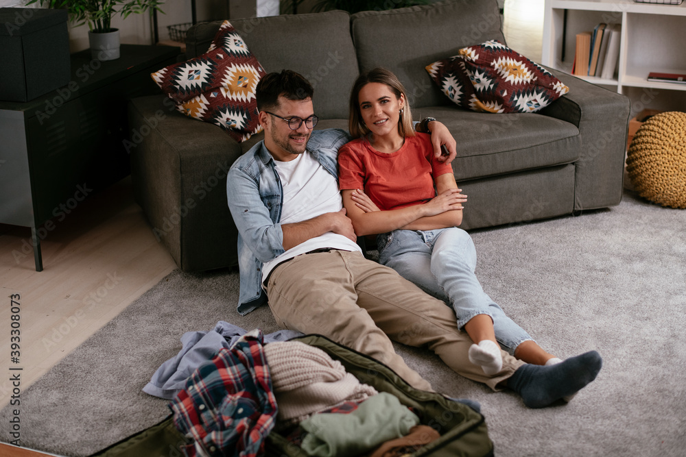 Obraz premium Loving couple packing clothes into travel bag. Boyfriend and girlfriend preparing for the trip.