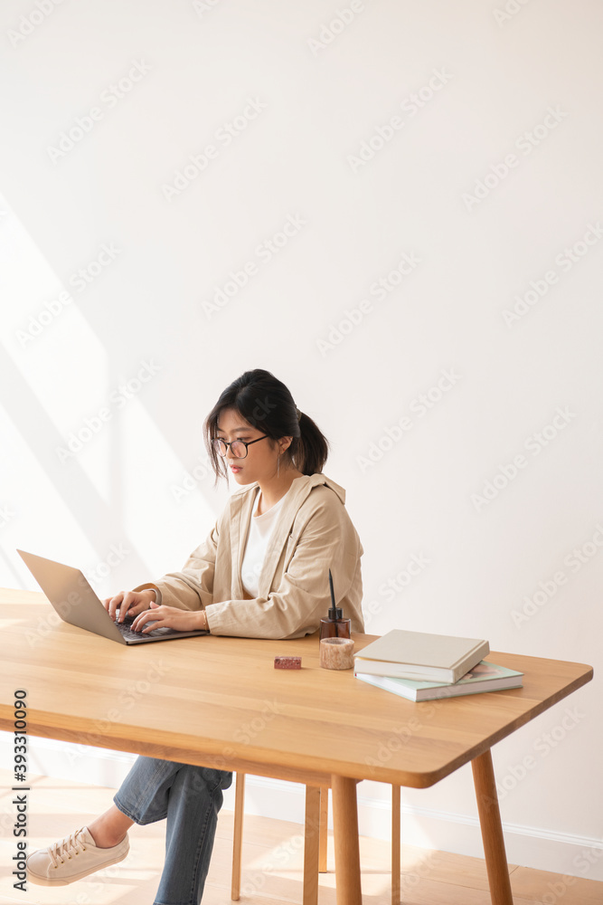 Studious Asian woman working at home using a laptop Studious Asian woman working at home using a laptop