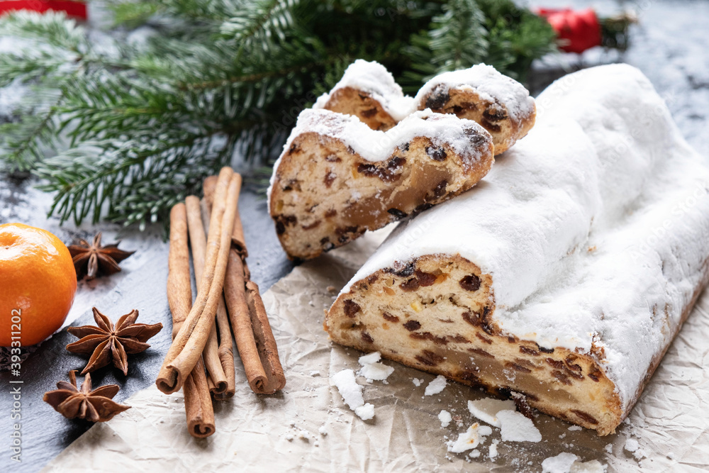 Christmas cake with marzipan, nuts and raisins on parchment paper, cinnamon and anise, spruce branches Christmas cake with marzipan, nuts and raisins on parchment paper, cinnamon and anise, spruce branches