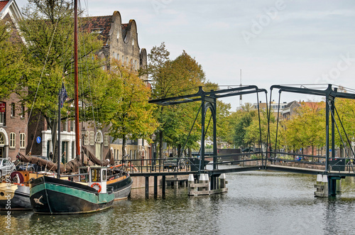 Schiedam, the Netherlands, September 16, 2020: historic sailboat and steel drawbridge near the Gin Museum at Lange Haven canal in autumn photo