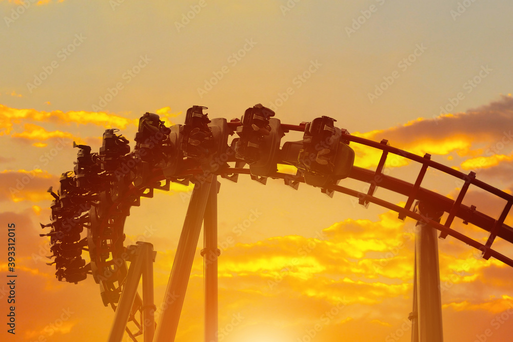 Roller coaster in the amusement park with the sunset background.

