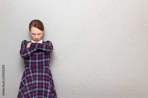 Portrait of angry disgruntled girl holding arms crossed on chest