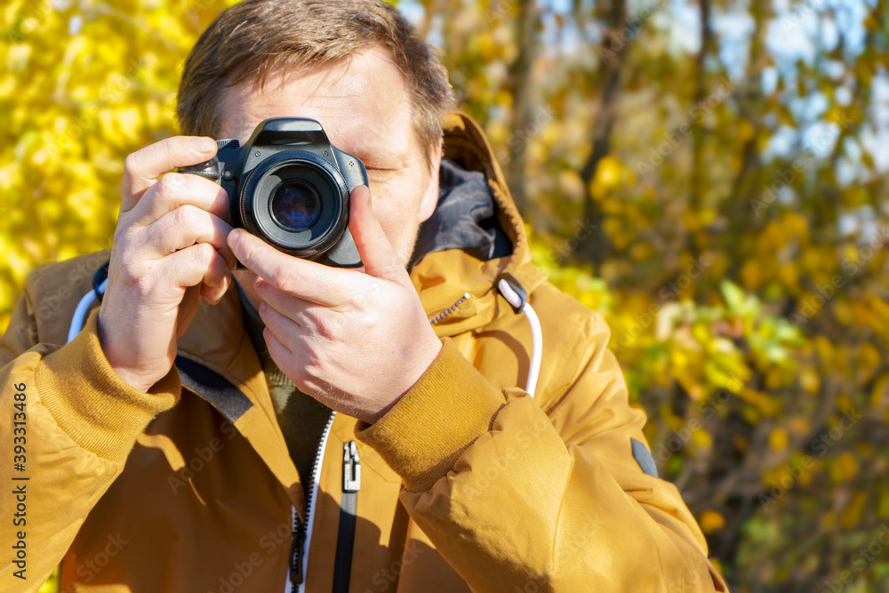 Professional male photographer taking outdoor photo in fall forest. Professional male photographer taking outdoor photo in fall forest.