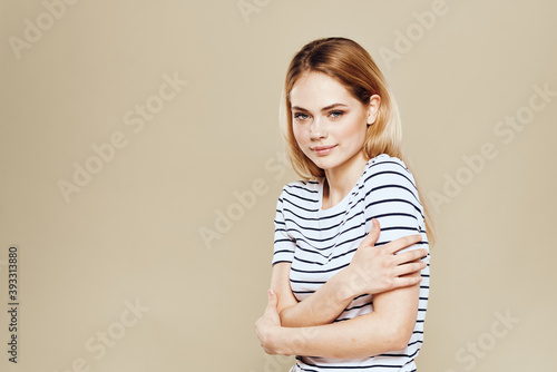 Cute blonde striped t-shirt smile lifestyle beige studio background 