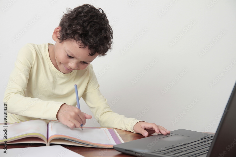 boy with book on table with laptop going back to school on white background stock photo boy with book on table with laptop going back to school on white background stock photo