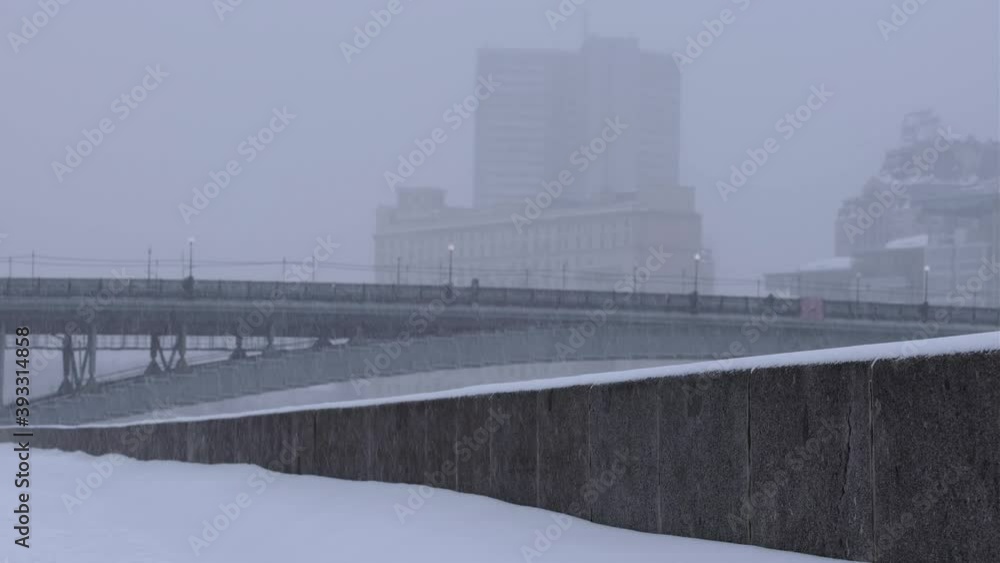 Snowy embankment with a city bridge on background, winter in Moscow, Russia Snowy embankment with a city bridge on background, winter in Moscow, Russia