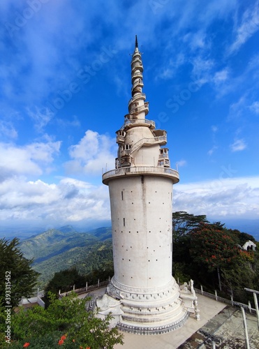 The spectacular Ambuluwawa tower in the Ambuluwawa Bio Diversity Complex which is situated in Gampola, Sri Lanka. The Tower is in the background of a clear blue morning sky and a mountainous landscape photo