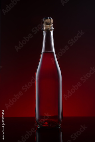 Bottle of Lambrusco wine on red dark background.