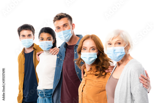 Multicultural friends in medical masks hugging isolated on white