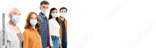 Young people in medical masks looking at camera near multiethnic friends isolated on white, banner