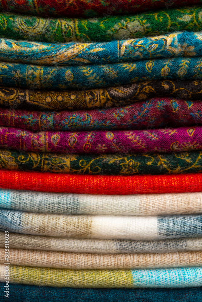 texture of nepalese shawls stacked in a pile on the market