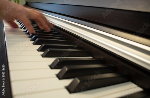 Teclado piano digital con mano tocando en movimiento.