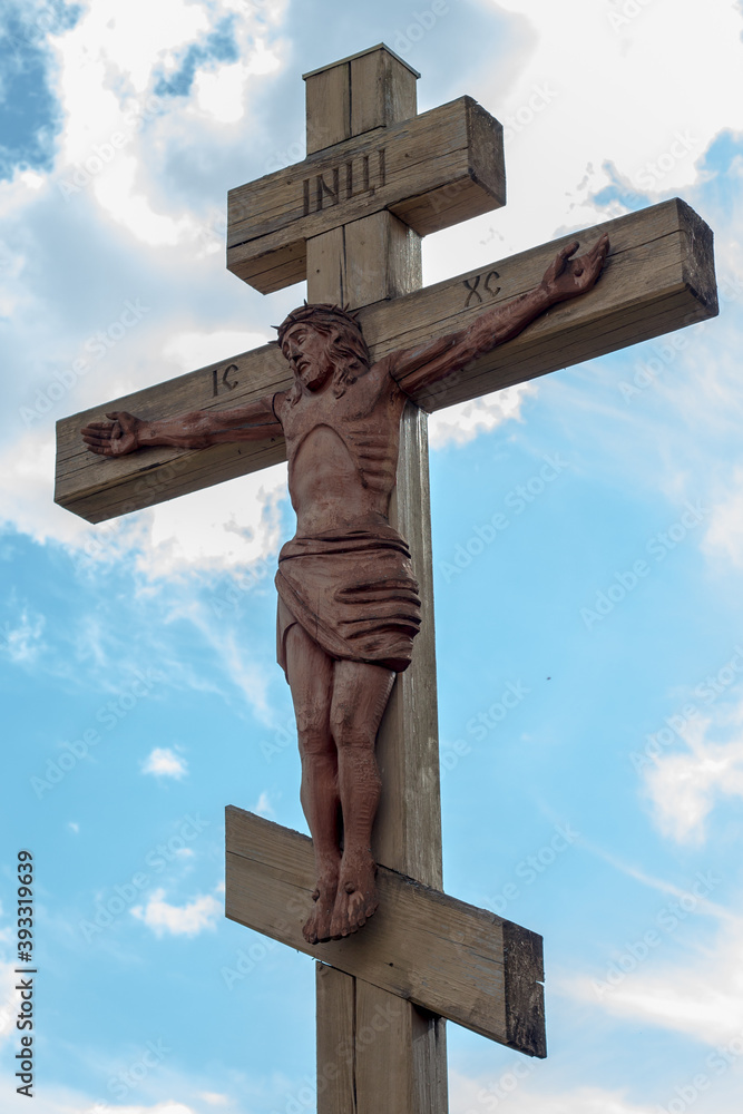 large wooden jesus crucifix against a blue sky large wooden jesus crucifix against a blue sky