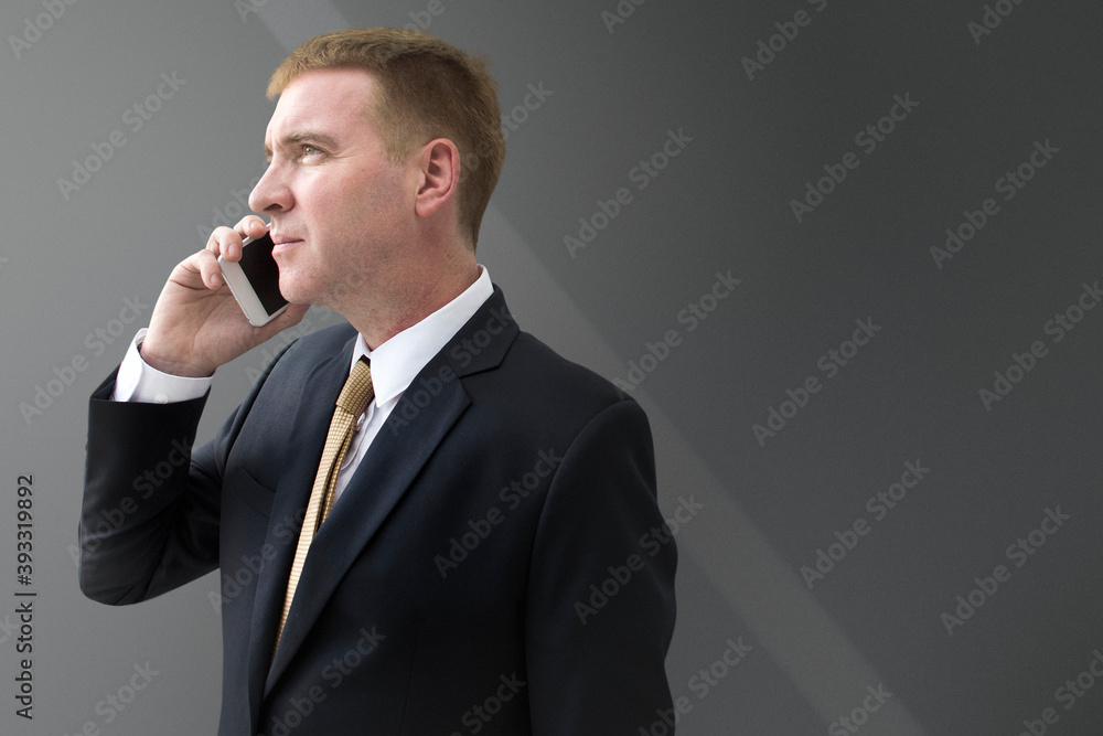 Businessman talking on phone on gray background Businessman talking on phone on gray background