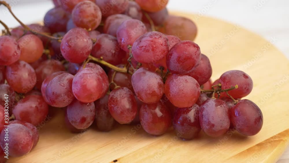 bunch of red grapes on wooden board bunch of red grapes on wooden board
