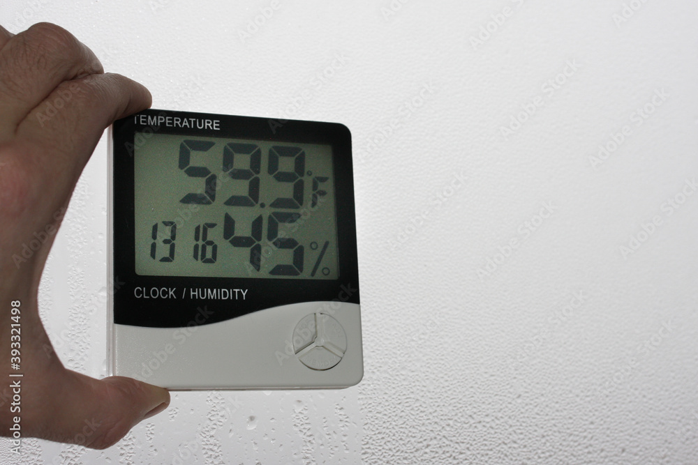 Measurement of air temperature, dew point, humidity with a device (hygrometer), against a background with condensation on the glass, high humidity Measurement of air temperature, dew point, humidity with a device (hygrometer), against a background with condensation on the glass, high humidity