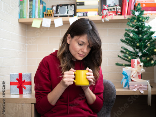 Happy woman with a mug in a hands waiting a Christmas