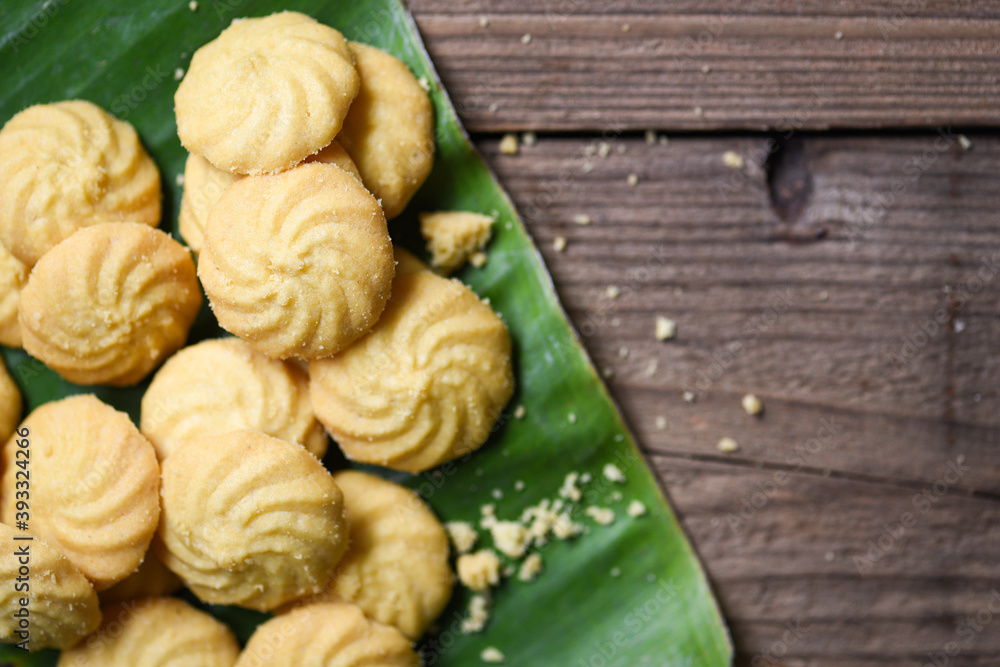 breakfast cookies vanilla on banana leaf and wooden background, mini cookies biscuits. breakfast cookies vanilla on banana leaf and wooden background, mini cookies biscuits.