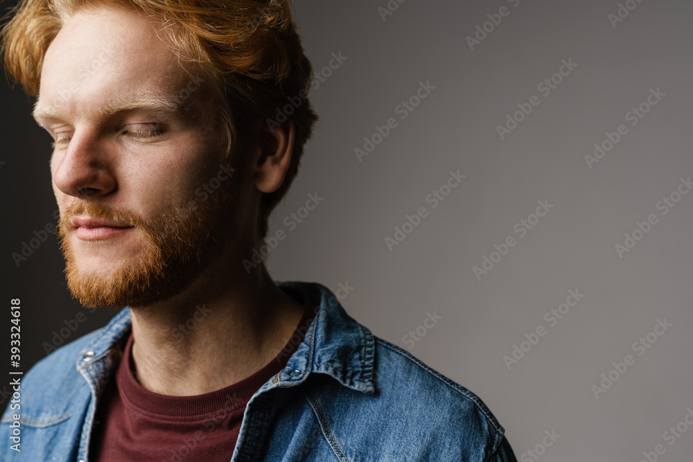 Handsome unshaven redhead guy posing with eyes closed on camera Handsome unshaven redhead guy posing with eyes closed on camera