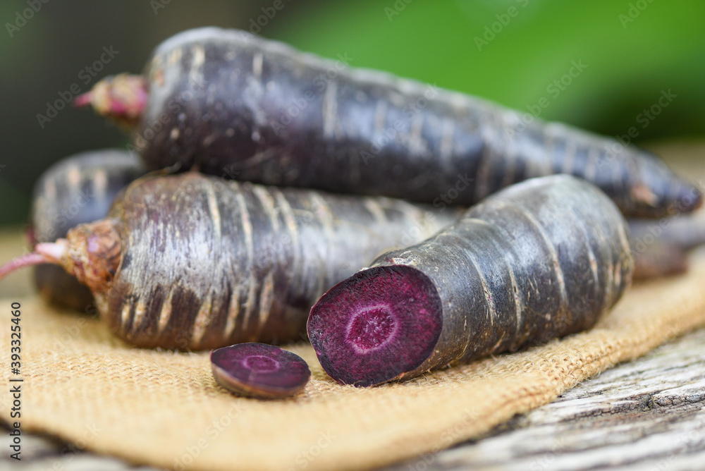 purple carrot on the sack, fresh carrot for cooking vegetarian on wooden table.