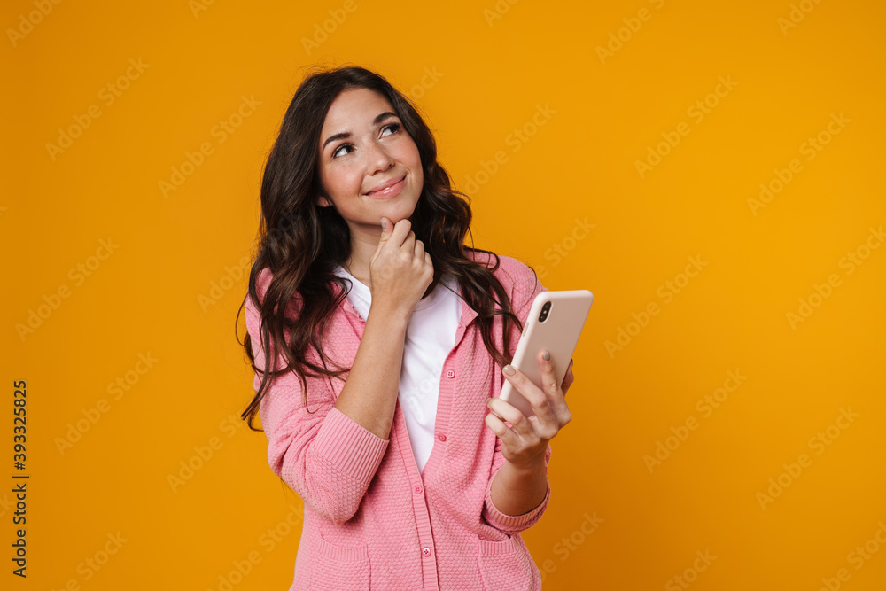 Pleased beautiful girl dreaming and using mobile phone Pleased beautiful girl dreaming and using mobile phone