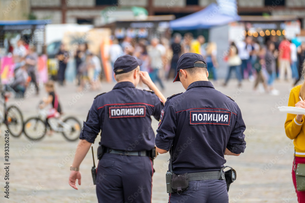 Naklejka premium Police officers patrolling square during fair
