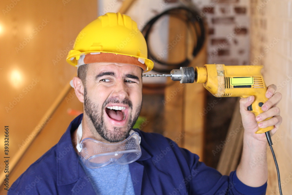 Stressed construction worker holding drill Stressed construction worker holding drill