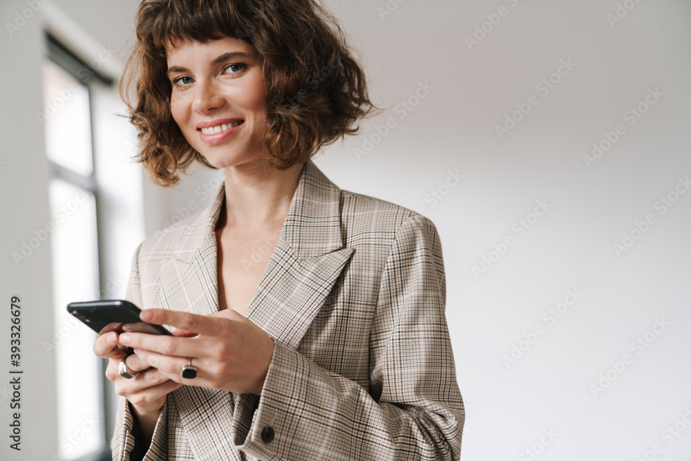 Happy beautiful businesswoman smiling and using mobile phone Happy beautiful businesswoman smiling and using mobile phone