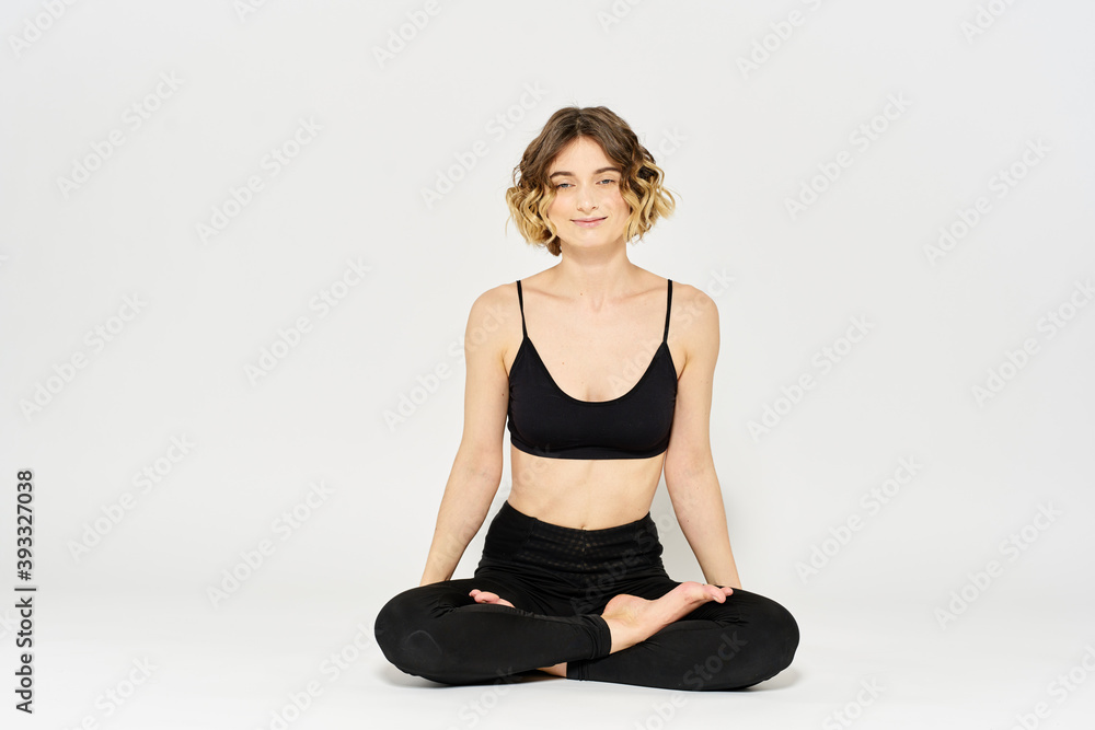 Woman in leggings meditate in a light room with her legs crossed yoga asana