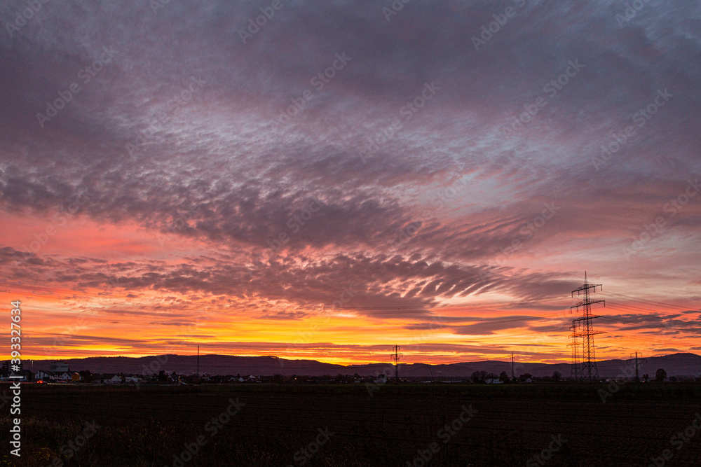 Image of a colorful and high-contrast sunrise with bright cloud formations taken in Germany