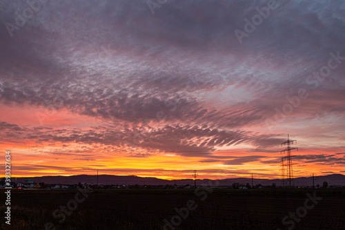 Image of a colorful and high-contrast sunrise with bright cloud formations taken in Germany