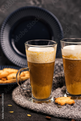 Pumpkin sweet spicy latte with autumn cookies and cinnamon. Grey knitted plaid