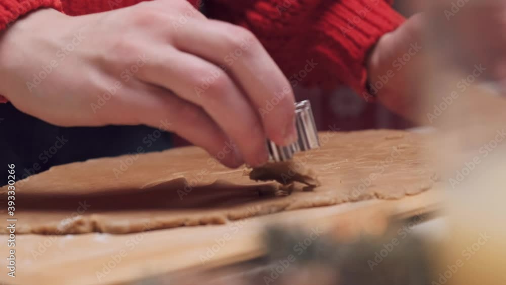 Women's hands cut out of thin dough cookies in the shape of snowflakes. Delicious Christmas snack. Cooking and recipe for Christmas cookies. Women's hands cut out of thin dough cookies in the shape of snowflakes. Delicious Christmas snack. Cooking and recipe for Christmas cookies.