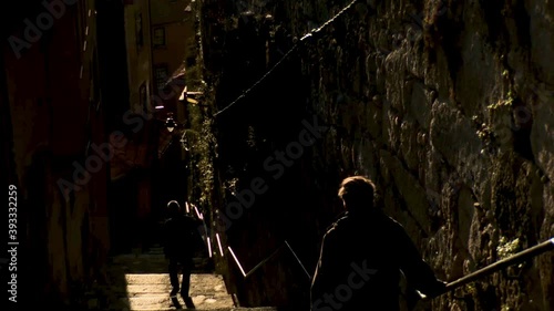 Two tourists coming down the narrow staircase between two buildings