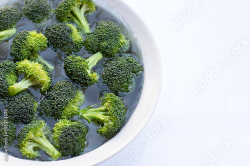 Obraz na plátně Fresh broccoli soaked in a white bowl of water