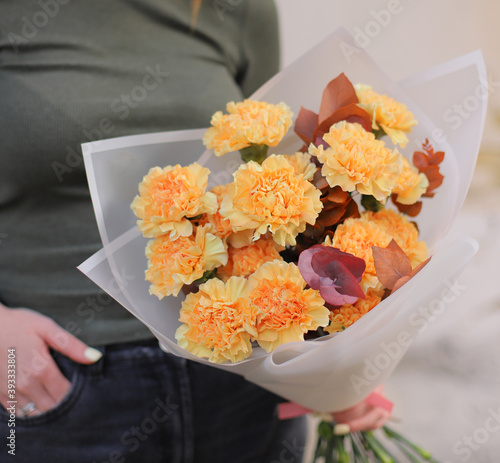 Fototapeta Naklejka Na Ścianę i Meble -  Beautiful bouquet of peach carnation and eucalyptus. Woman florist holding fresh beautiful bouquet.