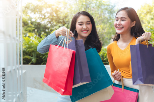 Asain woman in shopping. Happy woman with shopping bags enjoying in shopping.lifestyle concept.Smiling girl holding colour paper bag.Friends walking in shopping mall