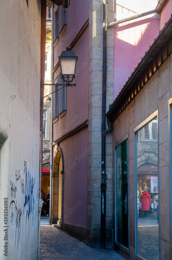 View into a narrow alley in the World Heritage city of Bamberg, mirroring in the shop window. High quality photo