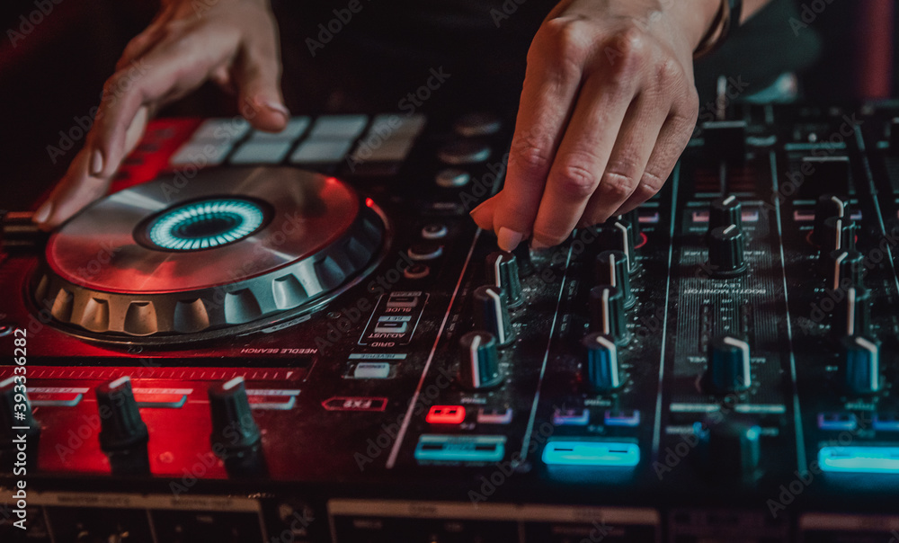 DJ Hands creating and regulating music on dj console mixer in concert nightclub stage DJ Hands creating and regulating music on dj console mixer in concert nightclub stage