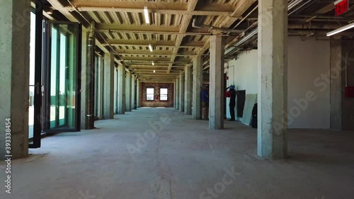 Interior view of an empty, unfinished office space that is under construction inside a large brick building. photo